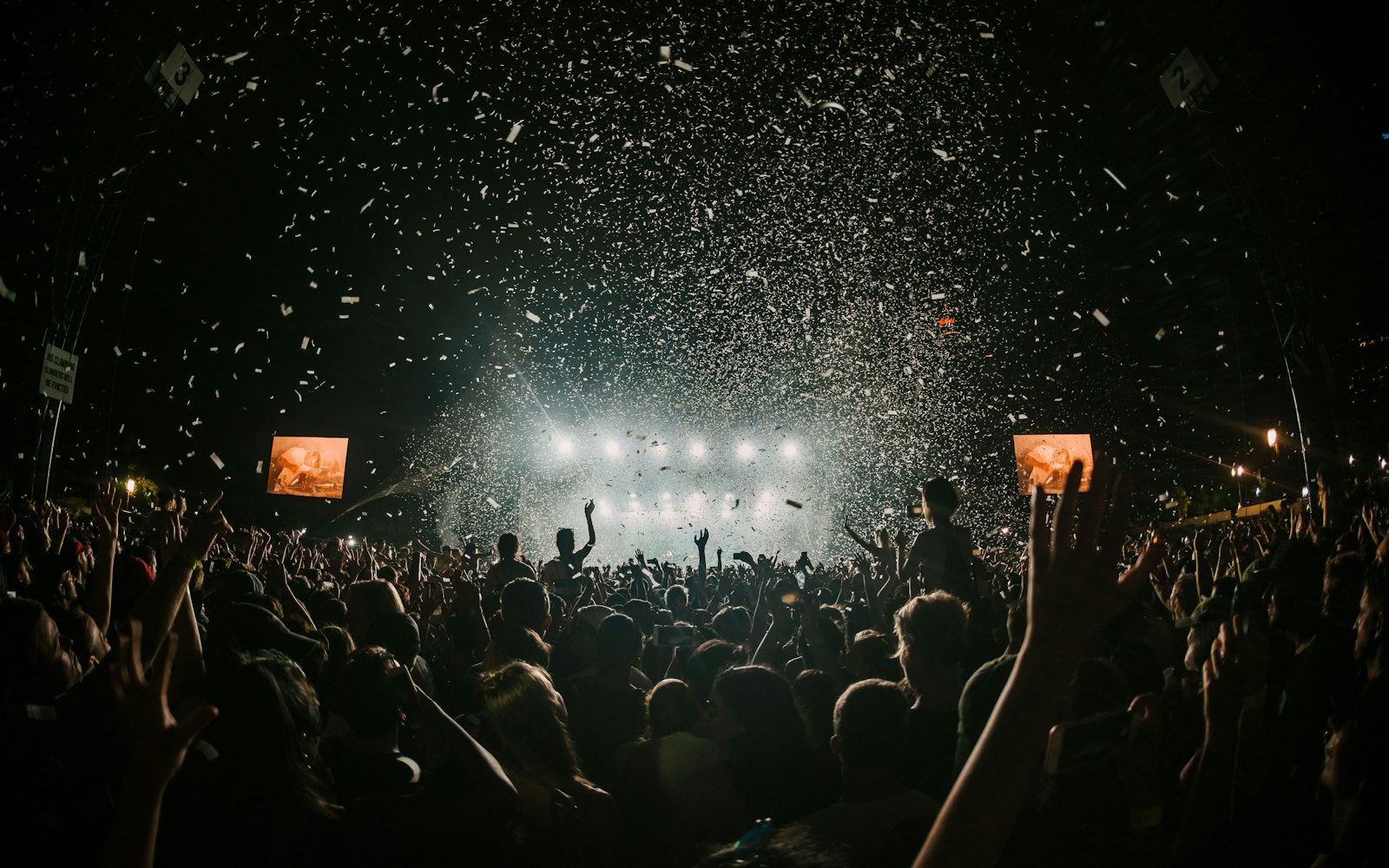 Gece konser alanında kalabalık ve sahne ışıkları